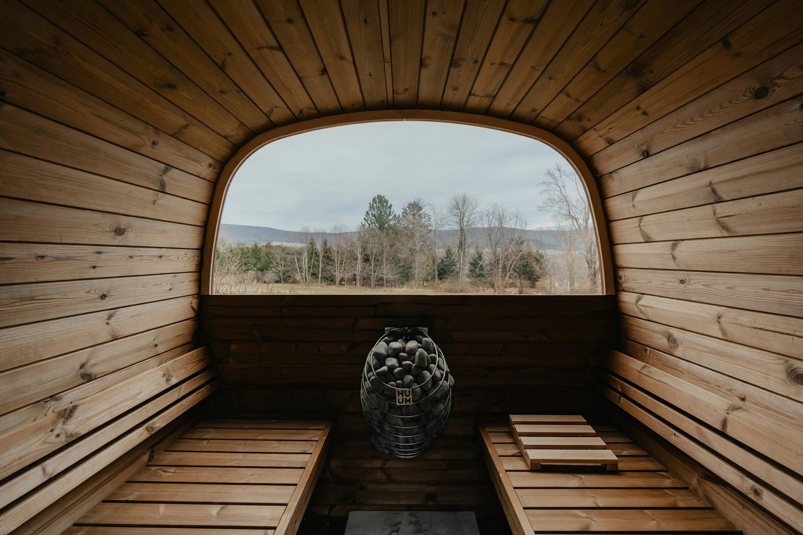 a wooden room with a large window and a bench